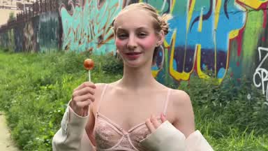 Sucking a lollipop outdoors