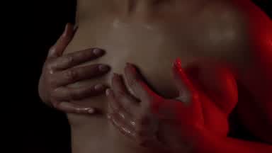 Oil massage on bare breasts