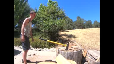 Splitting wood with a shirt on
