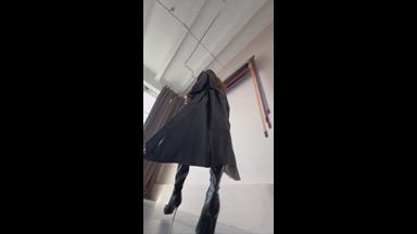 Mistress in a leather raincoat and stiletto boots