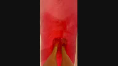 Feet in a bath with pink salt