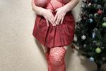 Near the Christmas tree in a red outfit!